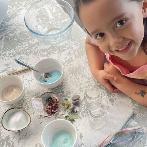 little girl sitting at a table waiting to make magic potions